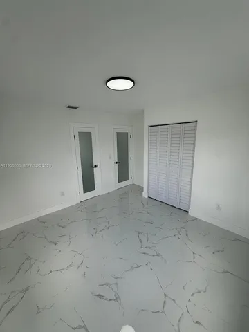 an empty room with windows and closet