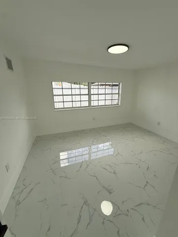 a view of a house with a yard and potted plants
