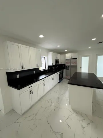 a kitchen with stainless steel appliances granite countertop a sink a stove and a microwave