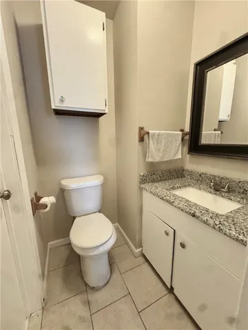 a bathroom with a granite countertop toilet sink and mirror