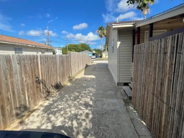a view of a pathway of a house with wooden fence