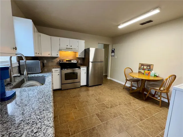 a kitchen with refrigerator and chairs