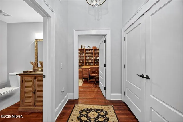 a view of a hallway with wooden floor and staircase