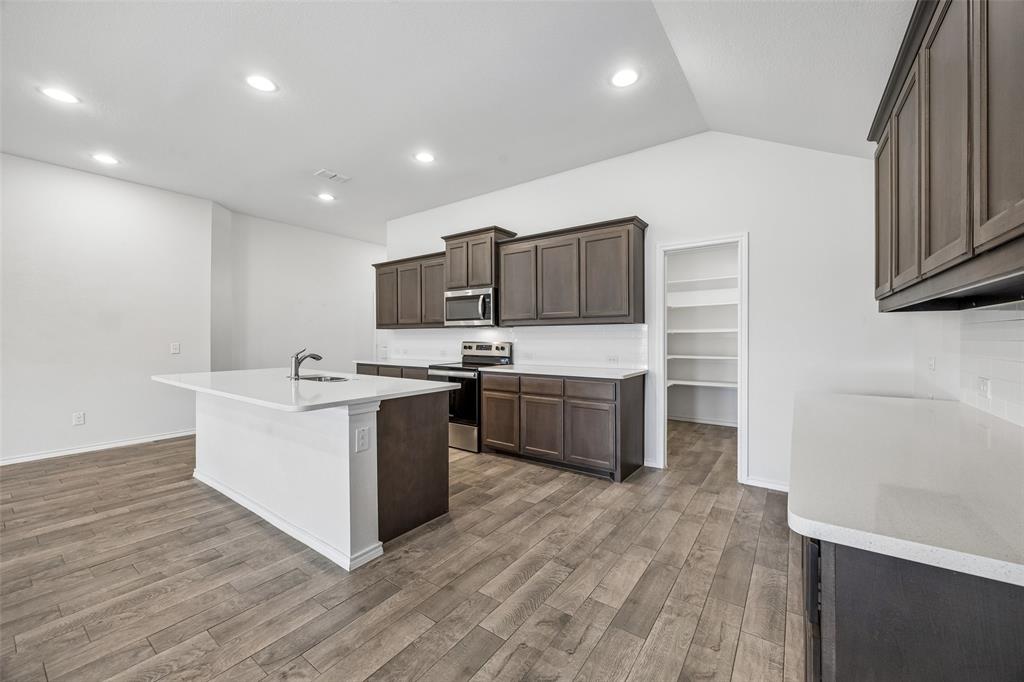 3807 Dogwood Road Melissa, TX 75454 - Photo 8 of 38 a kitchen with a sink wooden floor and stainless steel appliances