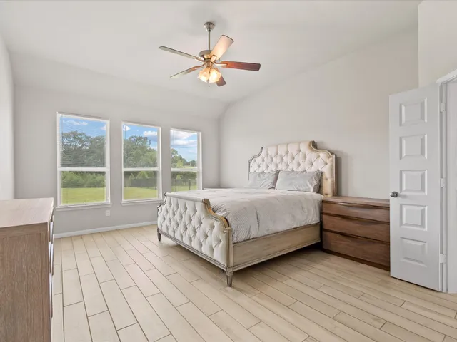 a bed sitting in a spacious bedroom next to a window