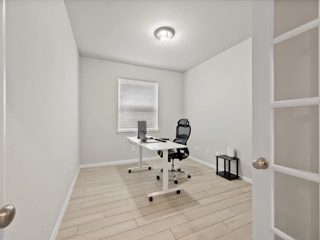 a room with a white bed and a dresser