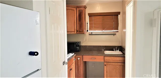 a view of a kitchen with white cabinets and refrigerator