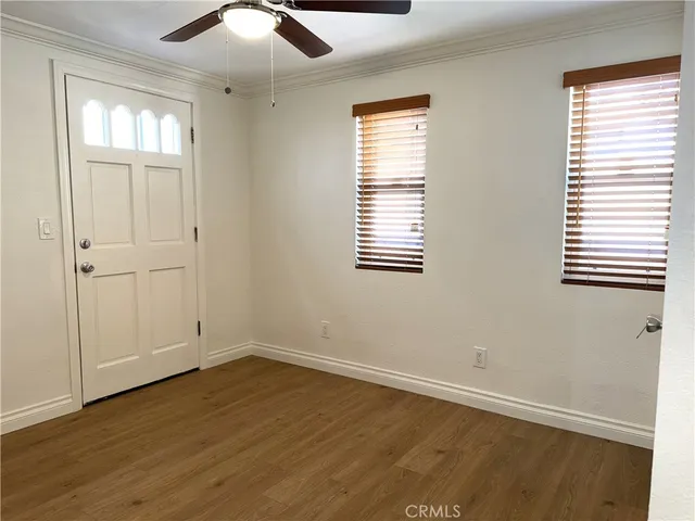 a view of an empty room with wooden floor