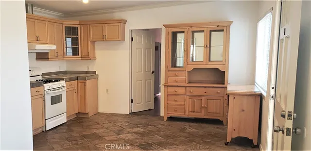 a kitchen with granite countertop a refrigerator stove top oven and sink