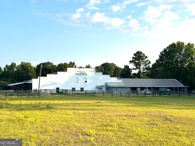a view of a swimming pool with lawn chairs under an umbrella