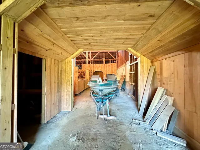 a view of a hallway with wooden floor and furniture