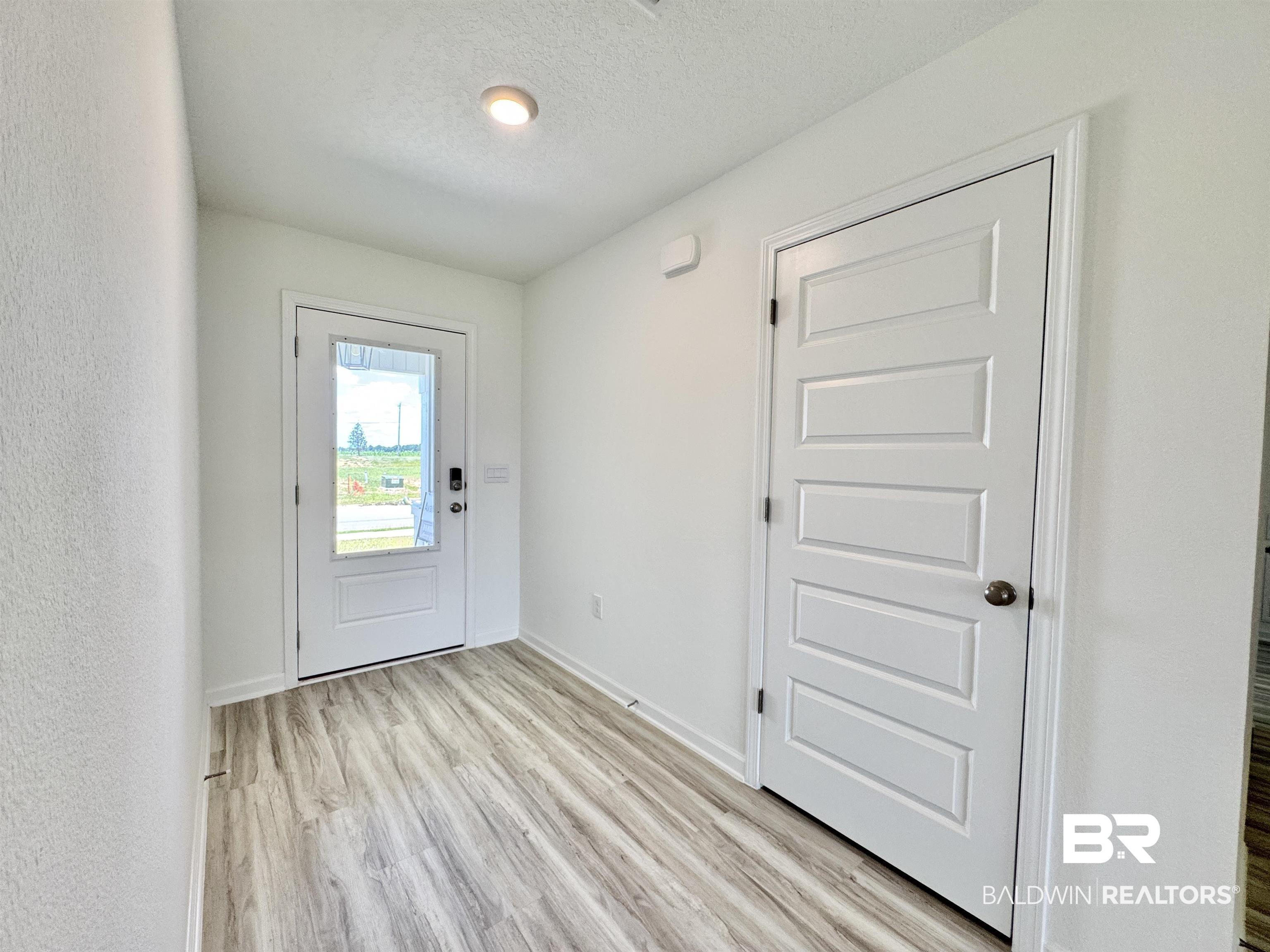 22072 Aleutian Avenue Foley, AL 36535 - Photo 3 of 47 Entrance foyer with light vinyl plank flooring, and storage closet