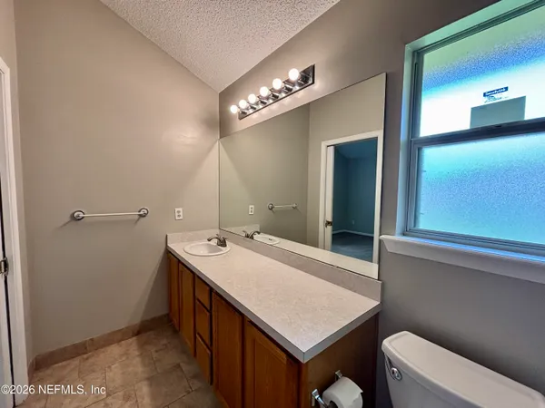 a bathroom with a sink a large mirror and a toilet