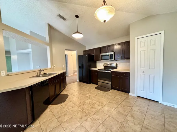 a kitchen with kitchen island granite countertop a sink counter top space appliances and cabinets