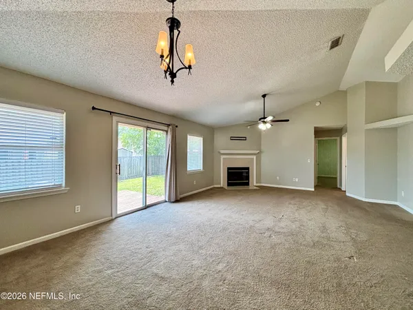 a view of empty room with windows and ceiling fan