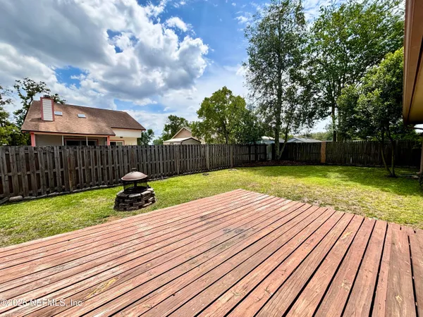 a view of a patio with table and chairs and wooden fence