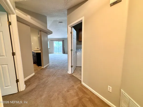 a view of a hallway with wooden floor and closet