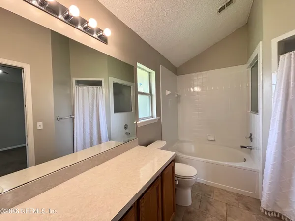 a bathroom with a granite countertop sink a toilet and shower