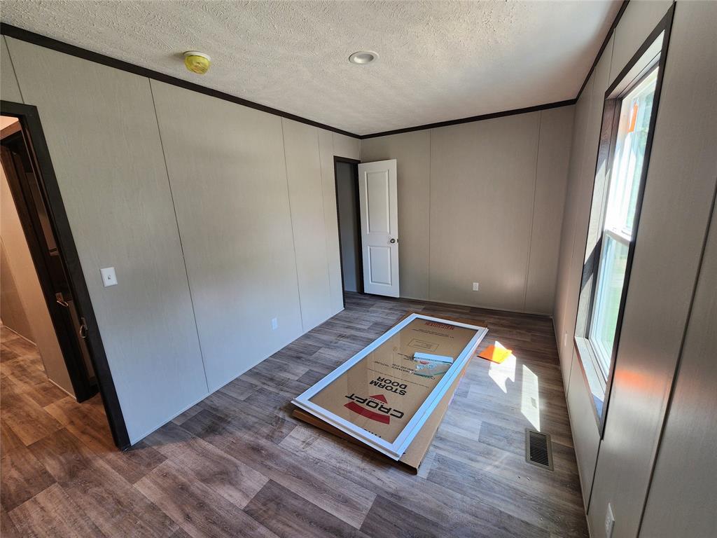 229 Maple Street Mabank, TX 75156 - Photo 12 of 25 a view of an empty room with wooden floor and a window