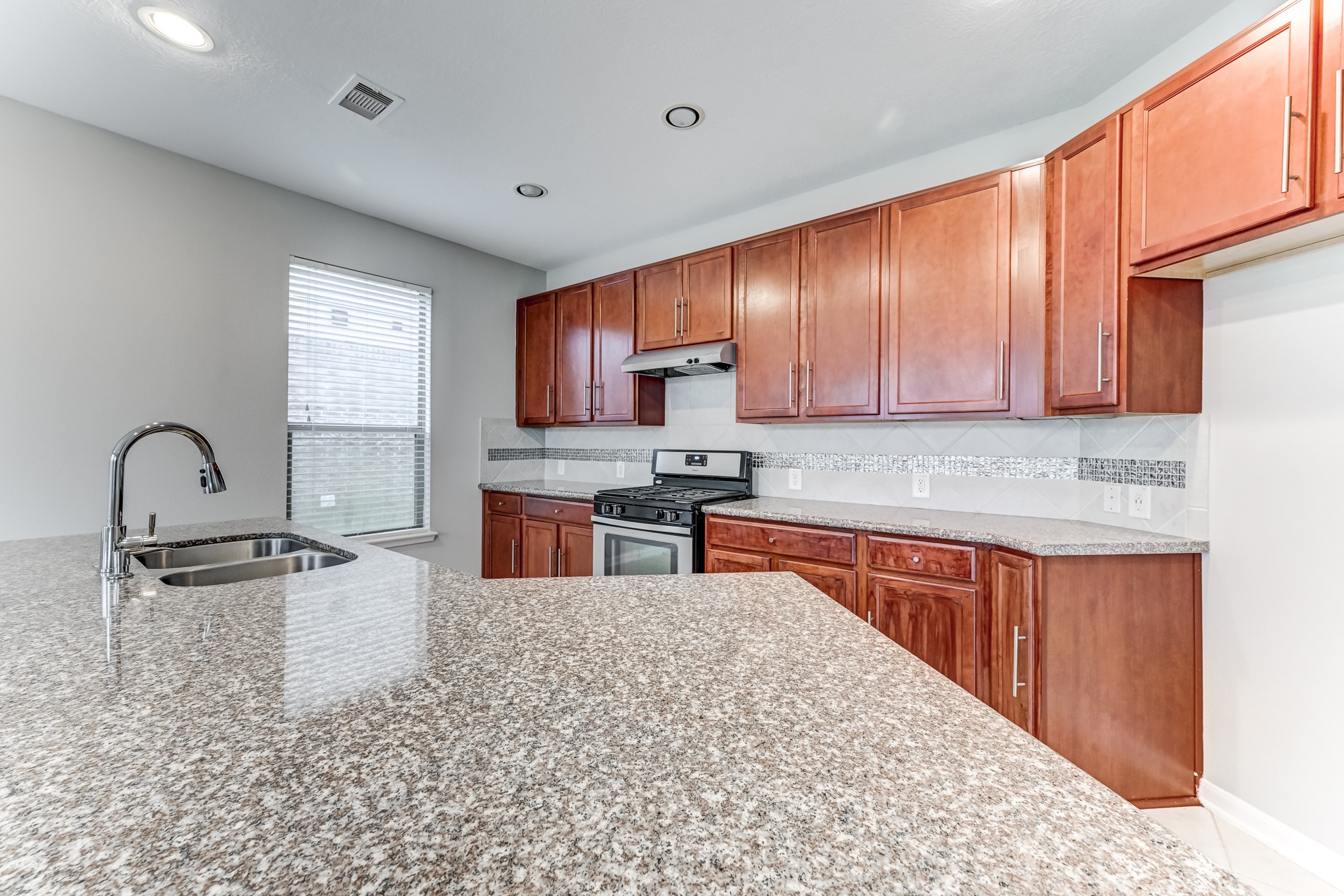 4706 Mint Trail Houston, TX 77066 - Photo 11 of 46 a kitchen with stainless steel appliances granite countertop a stove sink and cabinets