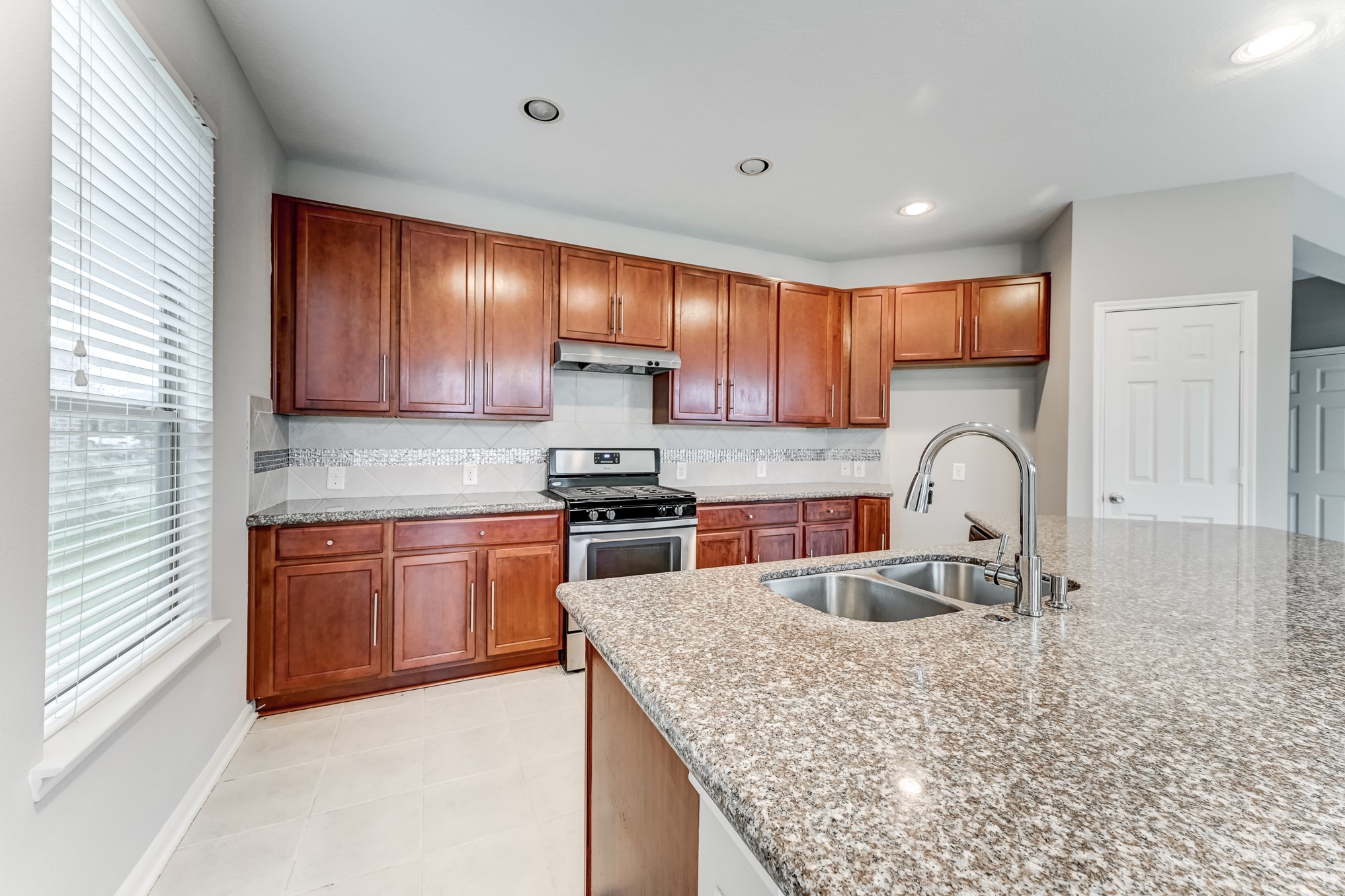 4706 Mint Trail Houston, TX 77066 - Photo 13 of 46 a kitchen with stainless steel appliances granite countertop a sink a stove and cabinets