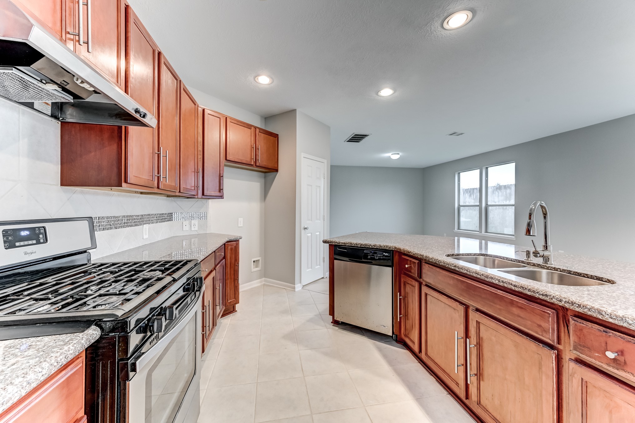 4706 Mint Trail Houston, TX 77066 - Photo 14 of 46 a kitchen with granite countertop a sink stove and cabinets