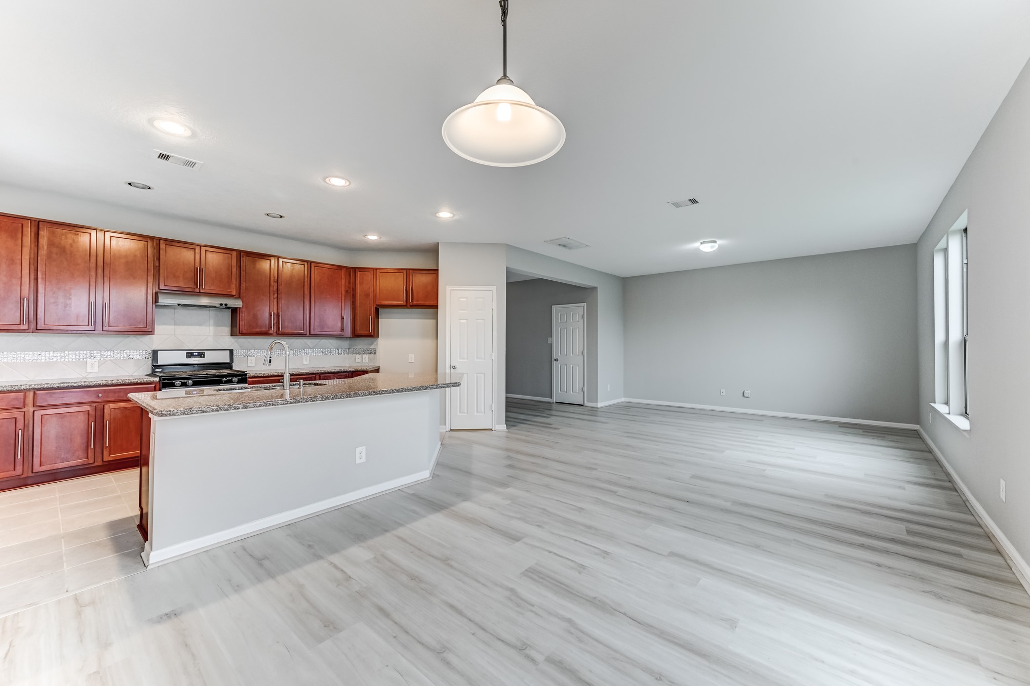 4706 Mint Trail Houston, TX 77066 - Photo 10 of 46 a kitchen with stainless steel appliances granite countertop a refrigerator a sink dishwasher a stove and white countertops with wooden floor