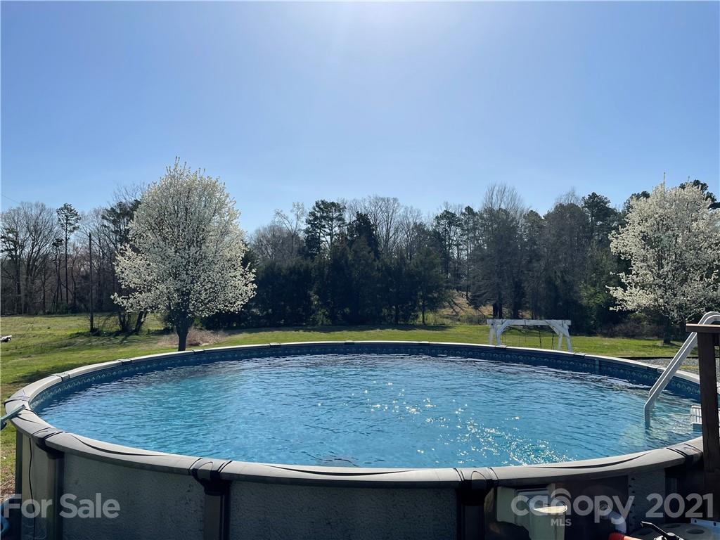 34908 Finger Road Mount Pleasant, NC 28124 - Photo 12 of 14 a view of a swimming pool with a yard and trees in the background