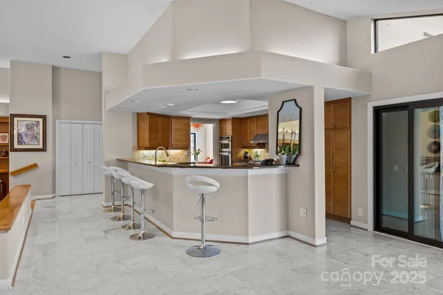 a living room with stainless steel appliances kitchen island granite countertop furniture and a refrigerator