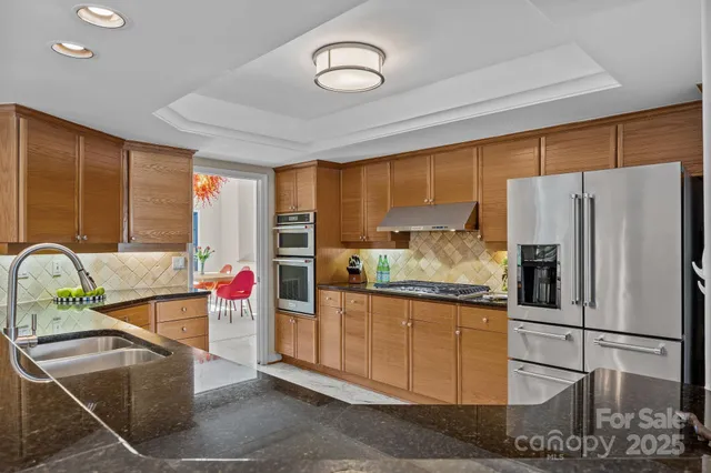 a kitchen with stainless steel appliances granite countertop a refrigerator and a sink