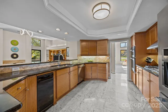 a large kitchen with stainless steel appliances granite countertop a stove and a sink