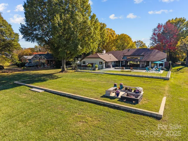 a view of a swimming pool with outdoor seating and a garden