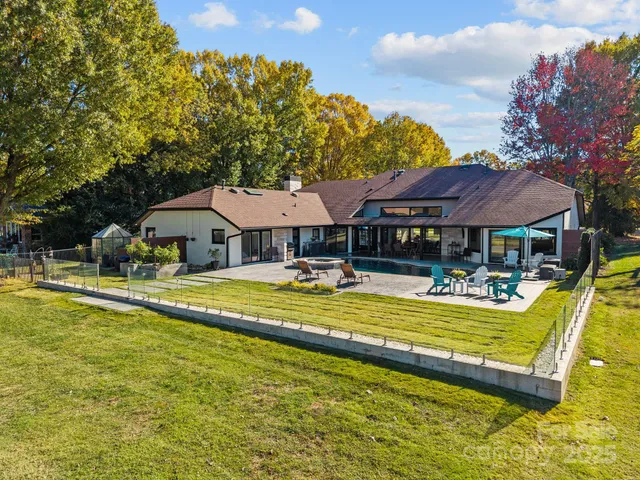 a view of a swimming pool with couches chairs under an umbrella