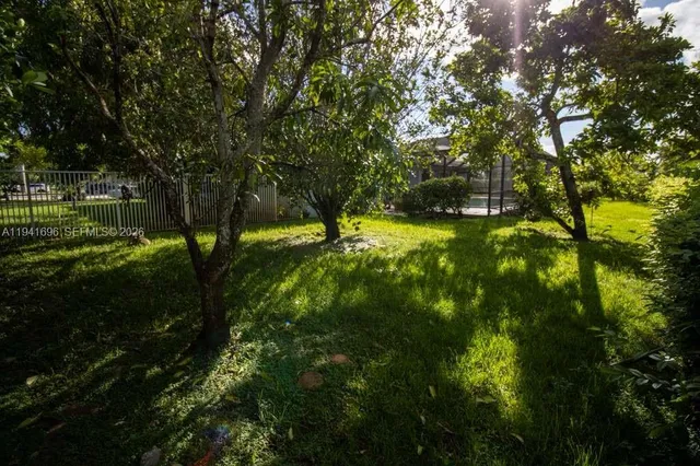 a view of a yard with wooden fence