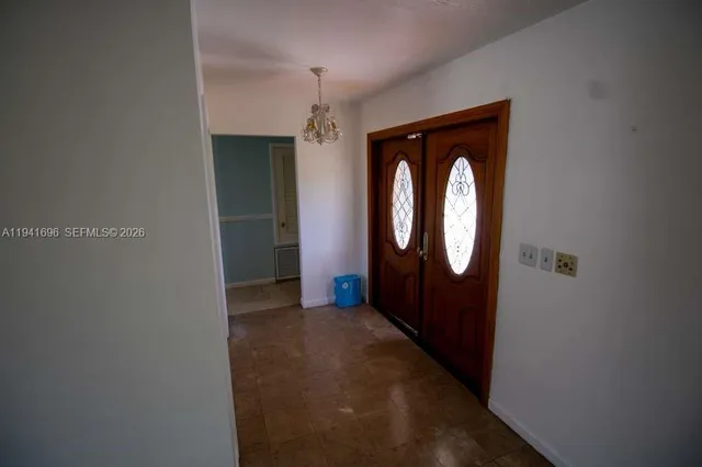 a view of a hallway with wooden floor and a window