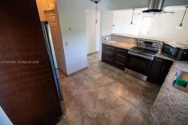 a kitchen with granite countertop a stove and a refrigerator