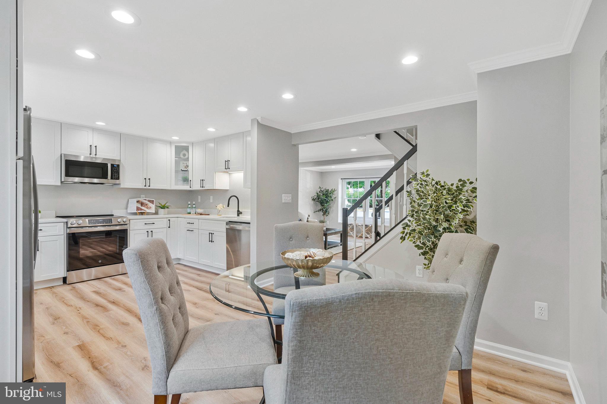 1628 Barnstead Drive Reston, VA 20194 - Photo 11 of 41 a kitchen with a table chairs refrigerator and microwave