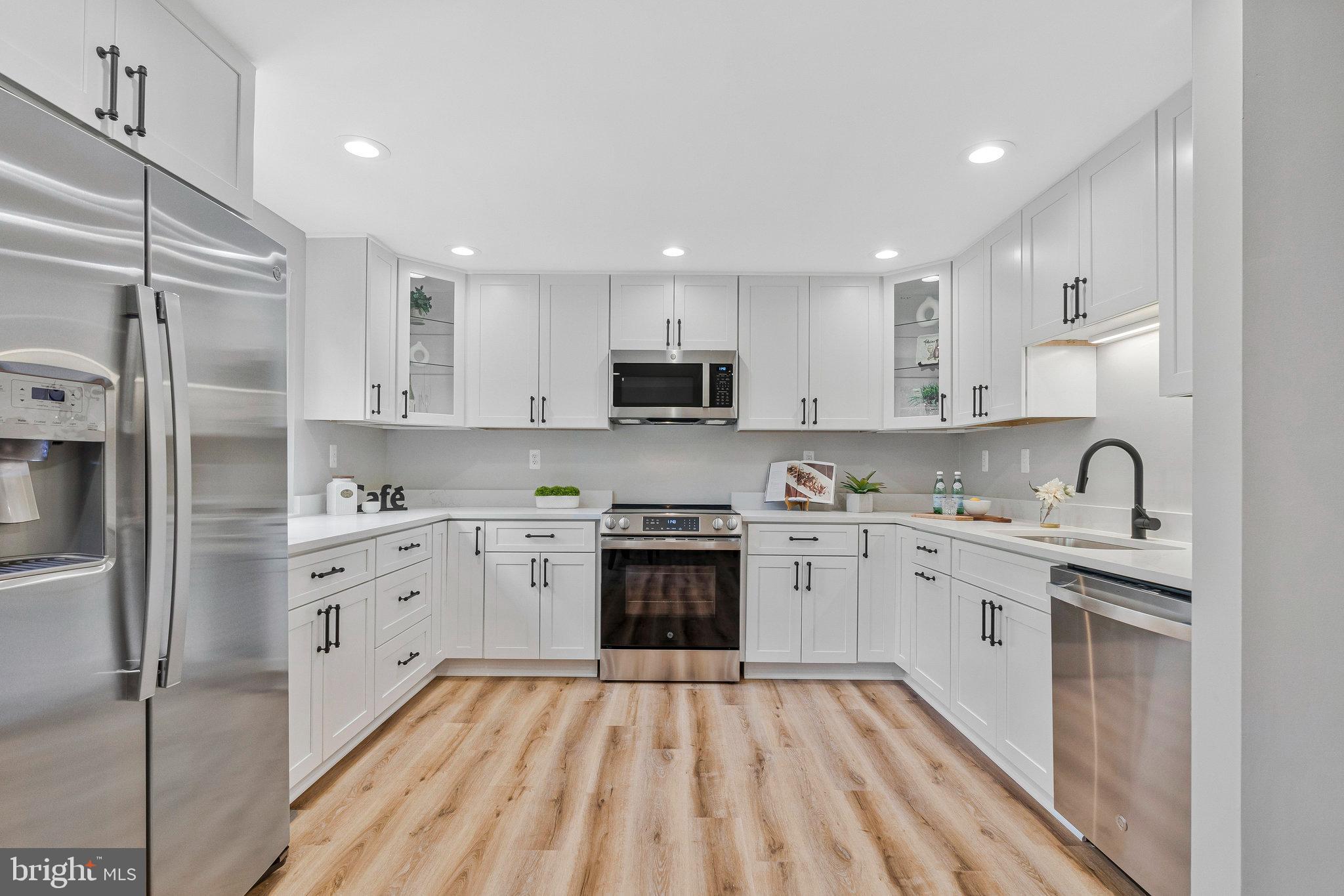 1628 Barnstead Drive Reston, VA 20194 - Photo 13 of 41 a large kitchen with stainless steel appliances granite countertop a stove top oven a sink and a refrigerator