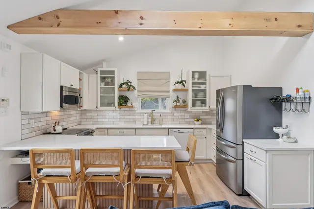 a kitchen with stainless steel appliances granite countertop a refrigerator and a stove top oven