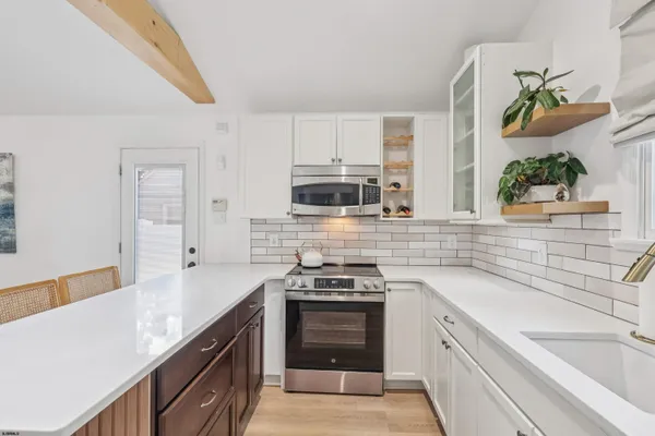 a kitchen with stainless steel appliances a stove sink microwave and cabinets