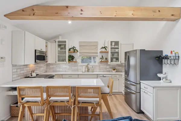 a kitchen with stainless steel appliances granite countertop a refrigerator and a stove top oven