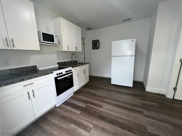 a kitchen with white cabinets and white appliances