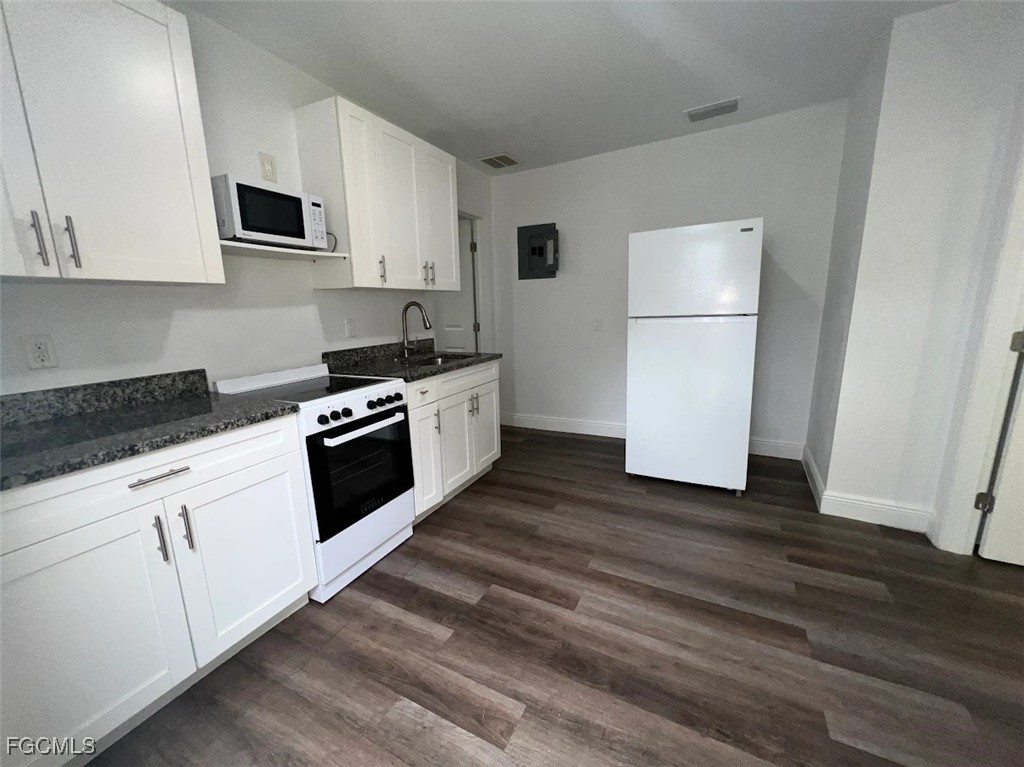 4180 Sabal Lane, Unit 2 Fort Myers, FL 33905 - Photo 5 of 11 a kitchen with granite countertop white cabinets and white appliances
