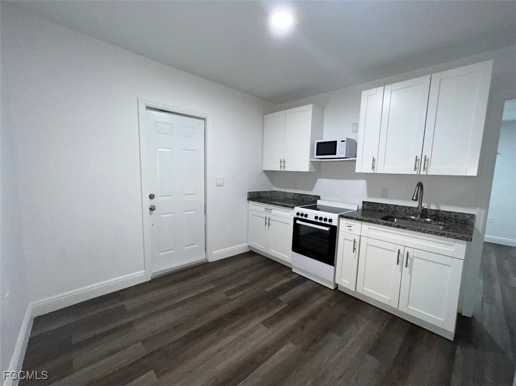4180 Sabal Lane, Unit 2 Fort Myers, FL 33905 - Photo 7 of 11 a kitchen with granite countertop white cabinets and white appliances