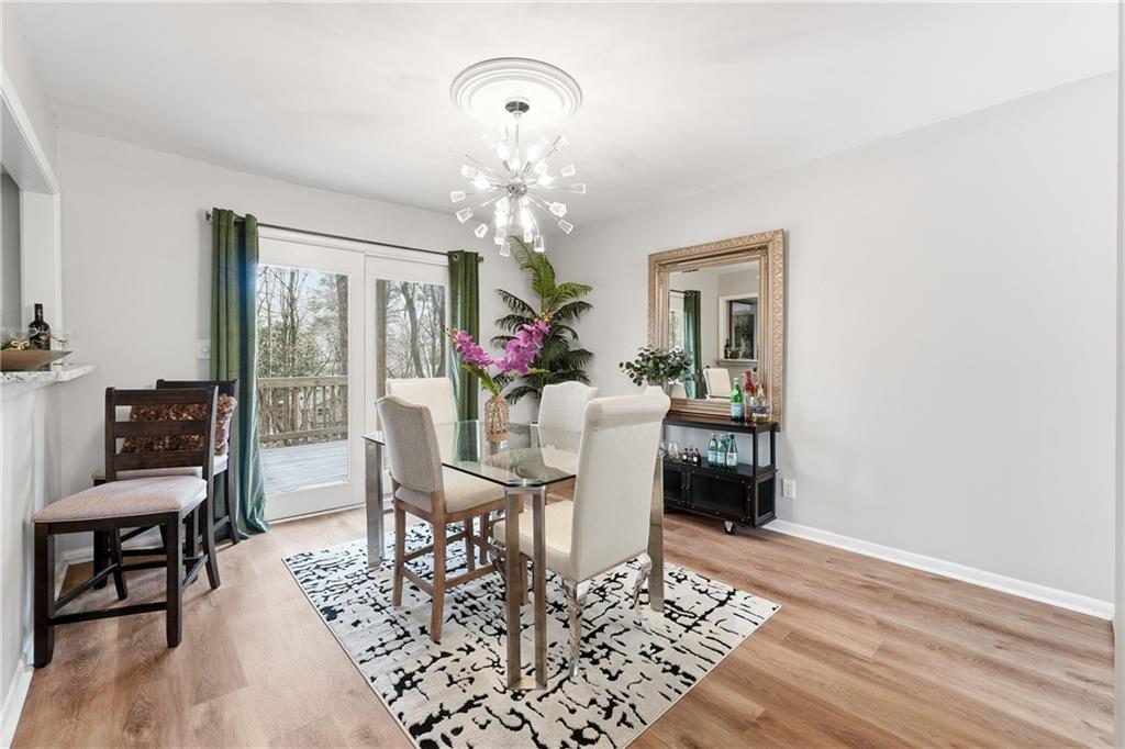 1720 Little Willeo Road Marietta, GA 30068 - Photo 6 of 26 a view of a dining room with furniture a chandelier and wooden floor