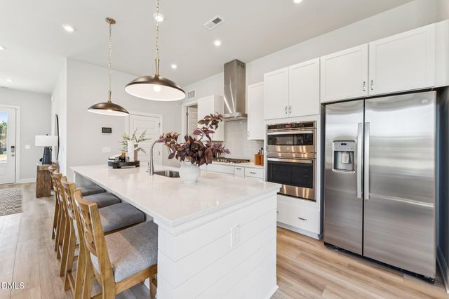 a spacious bedroom with a bed and a chandelier