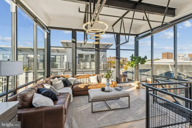 a living room with furniture and floor to ceiling windows