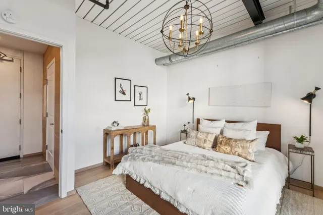 a bedroom with a bed and a chandelier