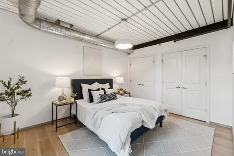 a spacious bedroom with a bed and a potted plant