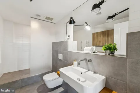 a bathroom with a sink toilet and a mirror
